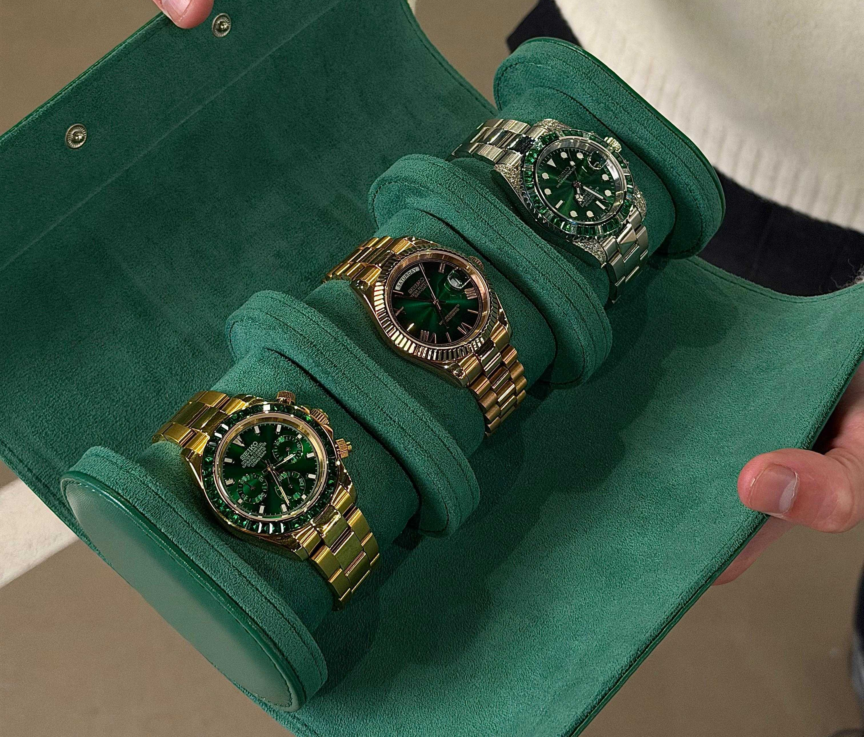 Three watches in green and gold cases on a green velvet surface.